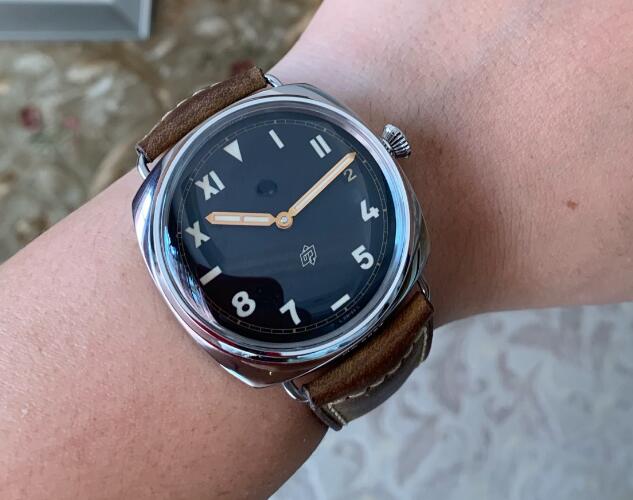 The Arabic numerals and Roman numerals hour markers are striking on the black dial.